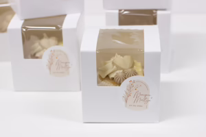 venster doosje met een cupcake erin, en een gepersonaliseerde sticker met namen en datum van de bruiloft, perfect als trouwbedankje