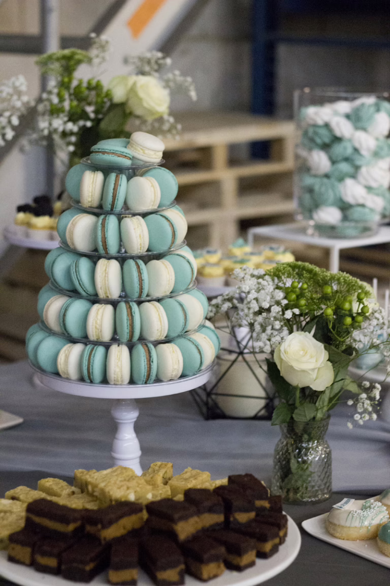Zakelijke sweet table in zwart-turquoise- branding kleuren. Op veel gebakjes logo decoratie. Donut wall, macaron toren, branded cupcakes - prachtig gepresenteerd.