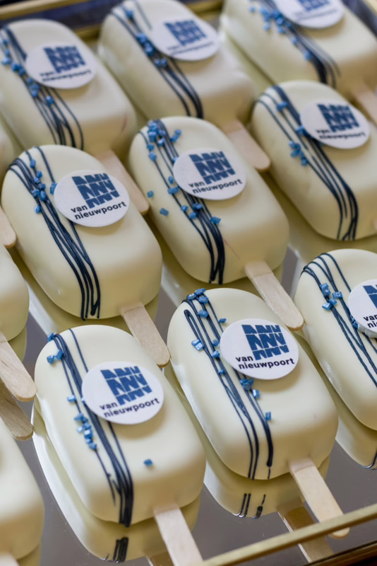 Branded witte mini magnums met logo en blauwe details, in huisstijl kleuren