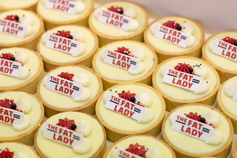 Branded witte chocolade tartelettes met witte en rode details en logo, in huisstijl kleuren