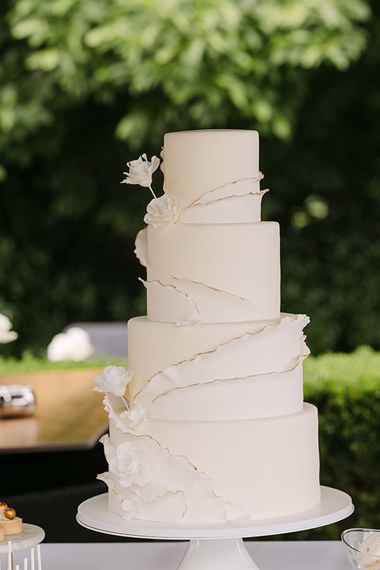 witte bruidstaart met suikerbloemen en ruffles